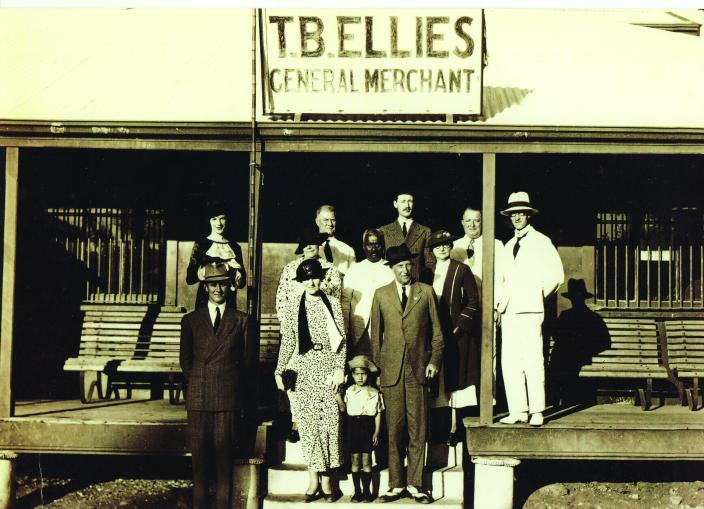 A group of people standing outside a shop. 